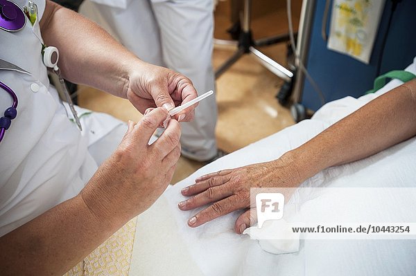 MODELL FREIGEGEBEN. Krankenschwester bereitet einen Patienten für einen IV-Anschluss vor Krankenschwester bereitet einen Patienten für einen IV-Anschluss vor