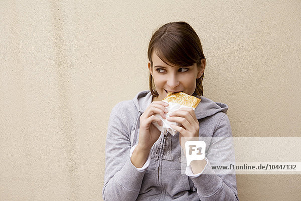 junge Frau isst ein getoastetes Sandwich