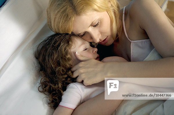 Mutter und Tochter  die auf dem Bett ausrutschen