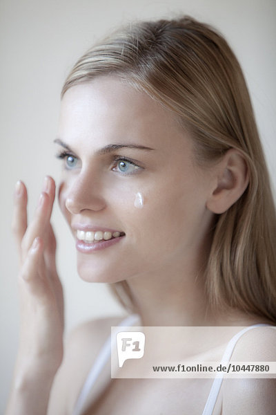 woman applies face cream
