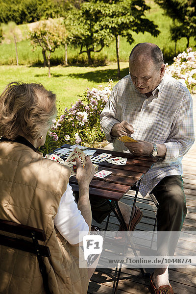 elderly couple who play cards in the garden
