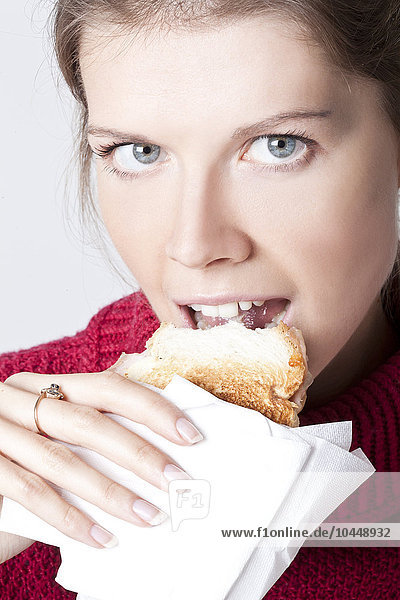 Frau isst einen Toast im Büro