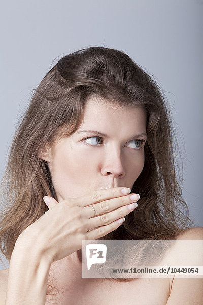 Frau bedeckt ihren Mund mit ihrer Hand