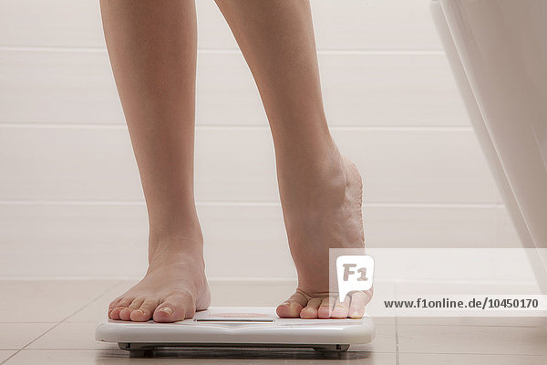 legs of woman standing on a weighing scale