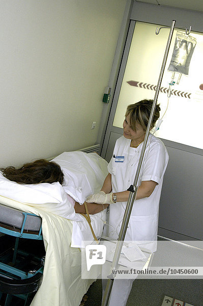 Ein Patient mit einer Krankenschwester  die eine Infusion anlegt.
