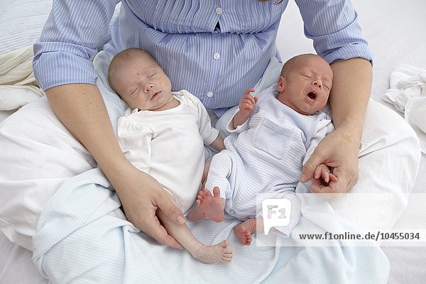 MODELL FREIGEGEBEN. Mutter und zwei Wochen alte zweieiige Zwillinge Mutter und zwei Wochen alte Zwillinge