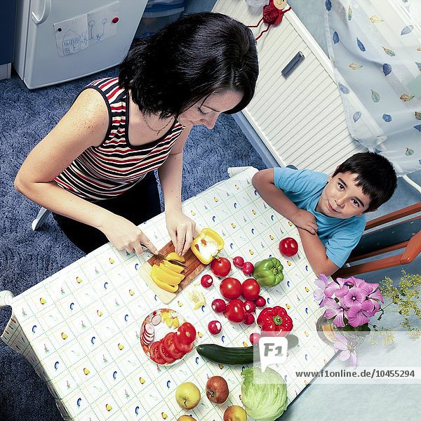 MODELL FREIGEGEBEN. Mutter und Sohn bereiten Gemüse zu Mutter und Sohn bereiten Gemüse zu