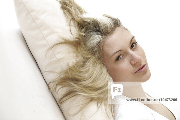 junge blonde Frau auf einem Sofa liegend