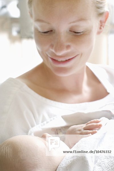 MODELL FREIGEGEBEN. Mutter und neugeborenes Baby. Frau in einer Entbindungsstation hält ihr neugeborenes Baby Mutter und neugeborenes Baby