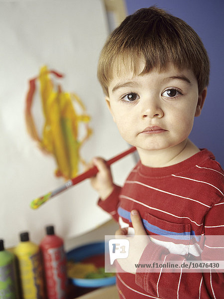 MODELL FREIGEGEBEN. Junge malt. Er ist drei Jahre alt. Junge Malerei