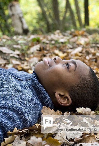 MODEL RELEASED. Smiling boy lying on autumn leaves. Smiling boy lying on autumn leaves