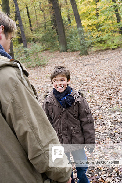MODELL FREIGEGEBEN. Vater und Sohn in einem Wald im Herbst Vater und Sohn in einem Wald