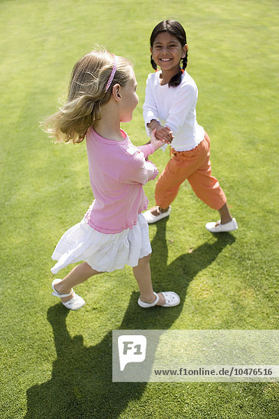 MODELL FREIGEGEBEN. Mädchen spielen auf Gras Mädchen spielen