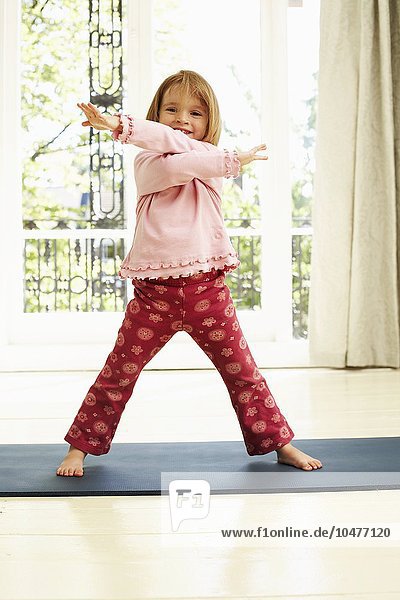 MODELL VERÖFFENTLICHT. Bewegung in der Kindheit. Mädchen tanzt auf einer Yogamatte. Sie ist vier Jahre alt. Childhood exercise