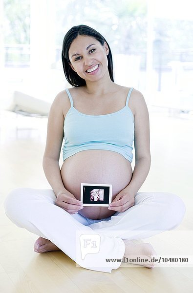 Schwangere Frau hält ihr Baby in der Hand