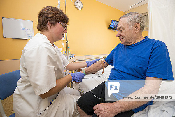 Reportage in the Internal Medecine and Geriatrics service in Saint-Philibert hospital in Lille  France. A nurse takes a blood sample from a patient in his hospital room.