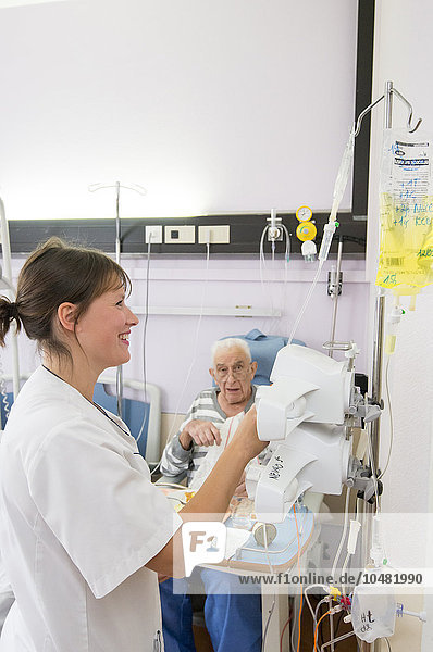 Reportage in the Geriatrics service in Saint-Vincent de Paul hospital in Lille  France. A nurse adjusts a drip in a hospital room.