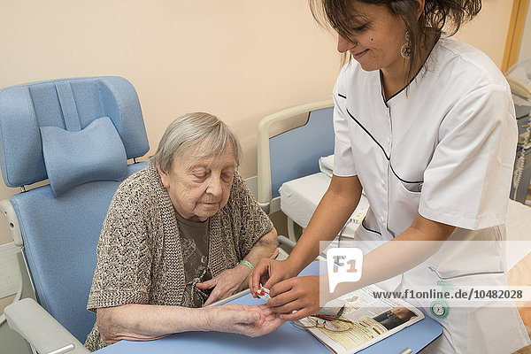 Reportage in the Follow-up Care and Rehabilitation service of Saint-Philibert hospital in Lille  France. A nurse gives a patient medicine in her hospital room.