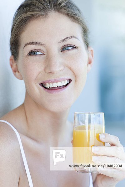 PROPERTY RELEASED. MODEL RELEASED. Woman drinking orange juice. Woman drinking orange juice