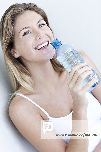 MODEL RELEASED. Woman drinking bottled water. Woman drinking bottled water