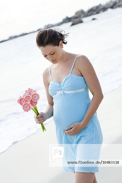 MODEL RELEASED. Pregnant woman on a beach. Pregnant woman