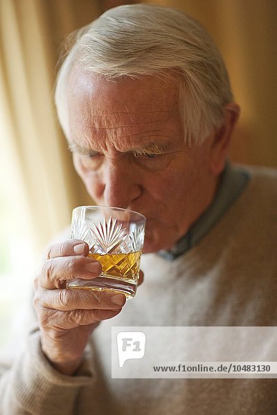 PROPERTY RELEASED. MODEL RELEASED. Senior man drinking whiskey. Senior man drinking whiskey
