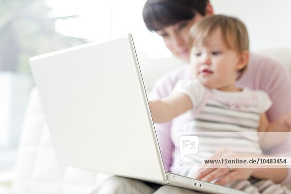 MODELL FREIGEGEBEN. Mutter und Tochter. Mutter und ihre 15 Monate alte Tochter benutzen einen Laptop Mutter und Tochter