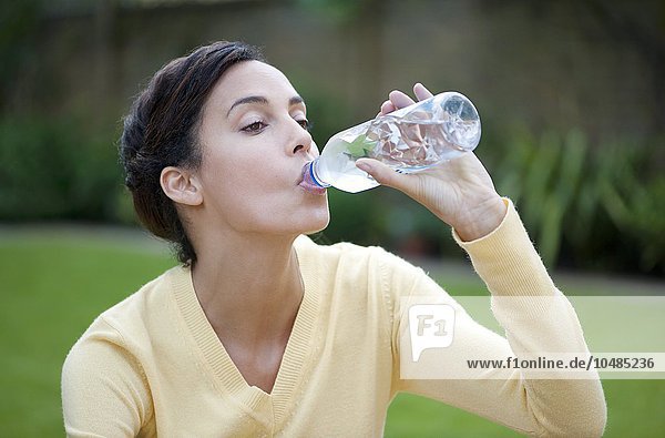Frau trinkt Wasser in Flaschen Frau trinkt Wasser in Flaschen