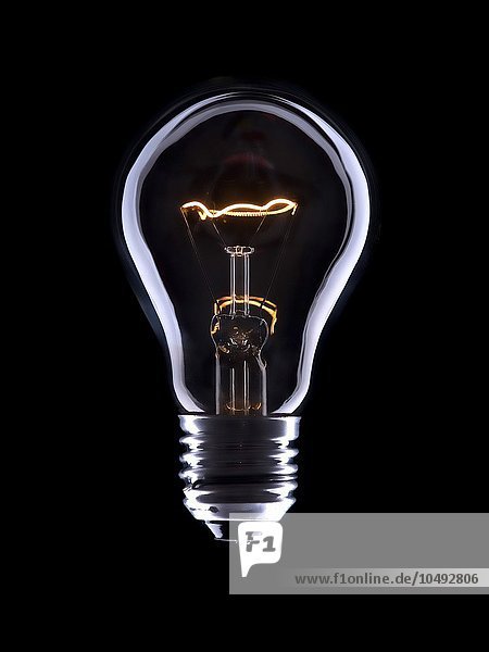 Elektrische Glühlampe mit einer Spirale auf schwarzem Hintergrund