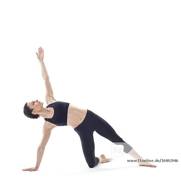 MODEL RELEASED. Woman practicing yoga. This is a variation of the side plank pose. Woman practicing yoga