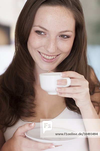 MODEL RELEASED. Young woman drinking coffee. Young woman drinking coffee
