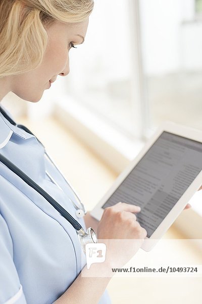 MODEL RELEASED. Nurse using a tablet computer. Nurse using a tablet computer