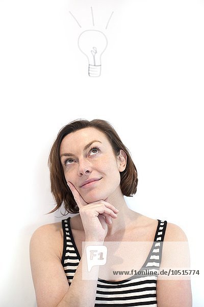 MODELL FREIGEGEBEN. Porträt einer Frau mit einer Glühbirne über ihrem Kopf Inspirationskonzept