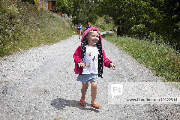 A little girl running on a path.