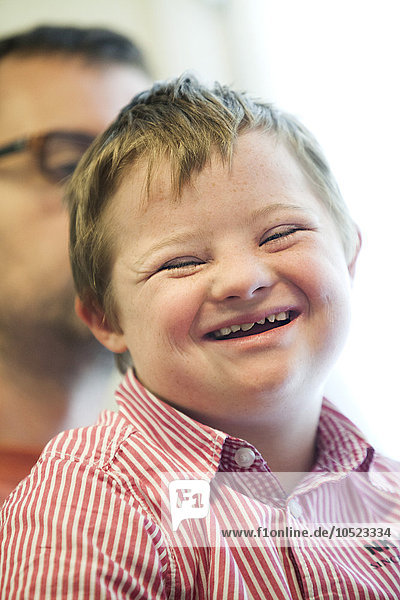 Ein Kind mit Down-Syndrom  zusammen mit seinem Vater.
