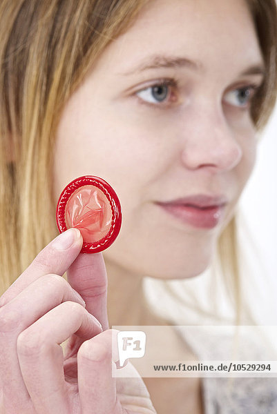 Frau hält ein Kondom