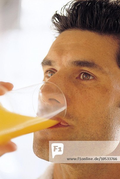 Mann trinkt ein Glas Orangensaft