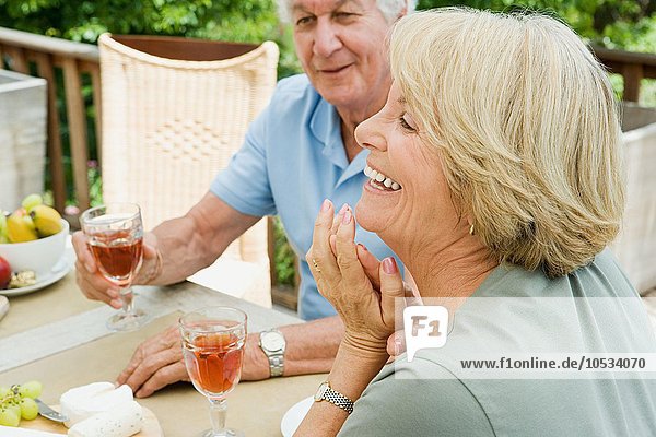 Senior couple eating and drinking wine