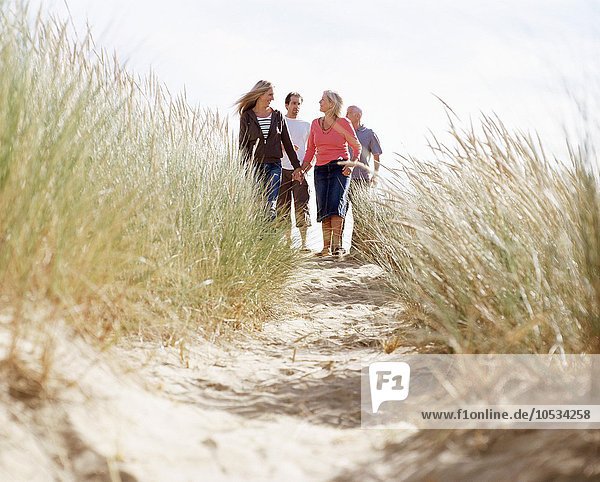 Family walking down a dune