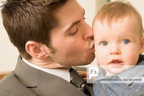 Mann  der sein Baby küsst