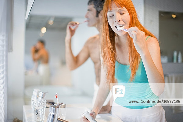 Couple brushing their teeth in bathroom