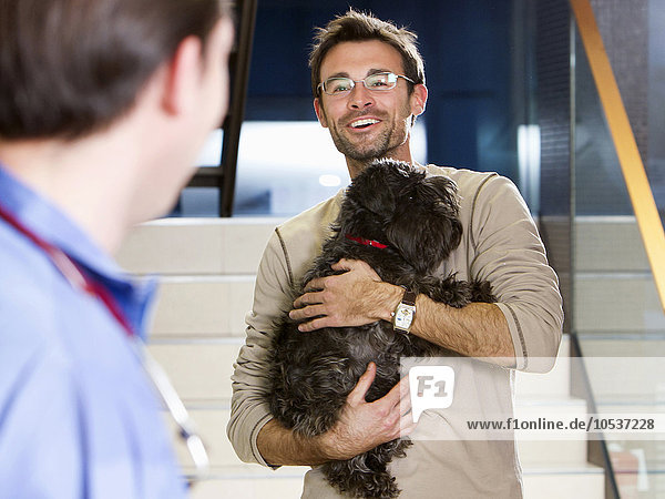 Mann mit Hund beim Tierarzt