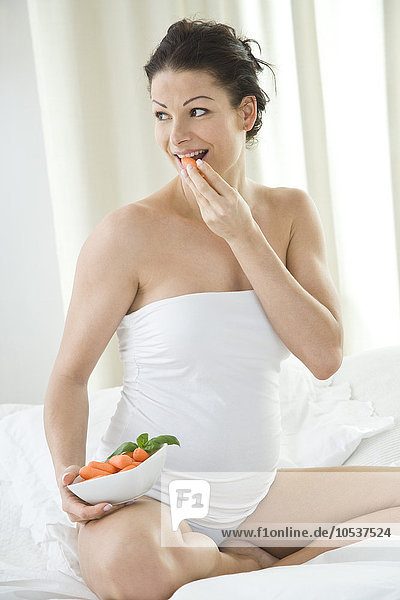 pregnant woman eating carrots