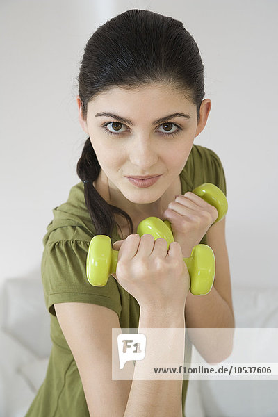 young woman training with dumbbells