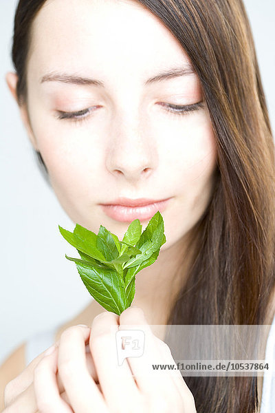 young woman holding fresh herbs
