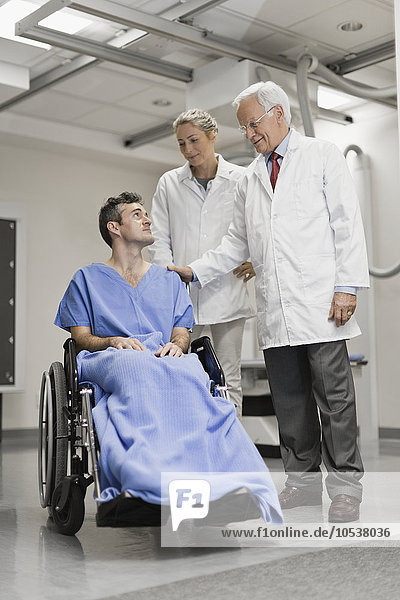 Ärzte im Gespräch mit Patienten im Rollstuhl