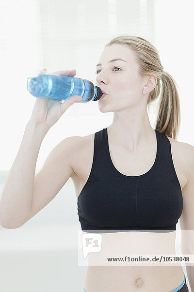 Frau trinkt Wasser während des Trainings