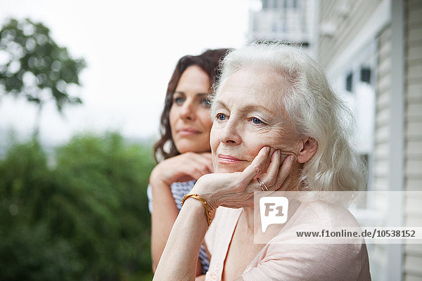 Senior woman and daughter relaxing on porch