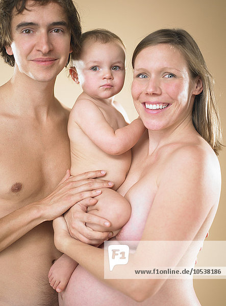 Eltern und Kleinkind posieren nackt