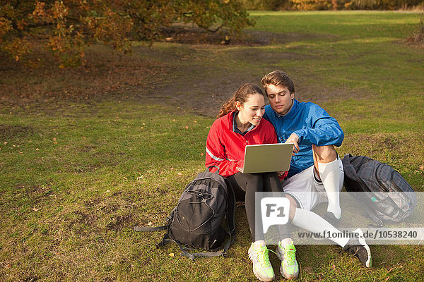 Junges Paar mit Laptop im Park